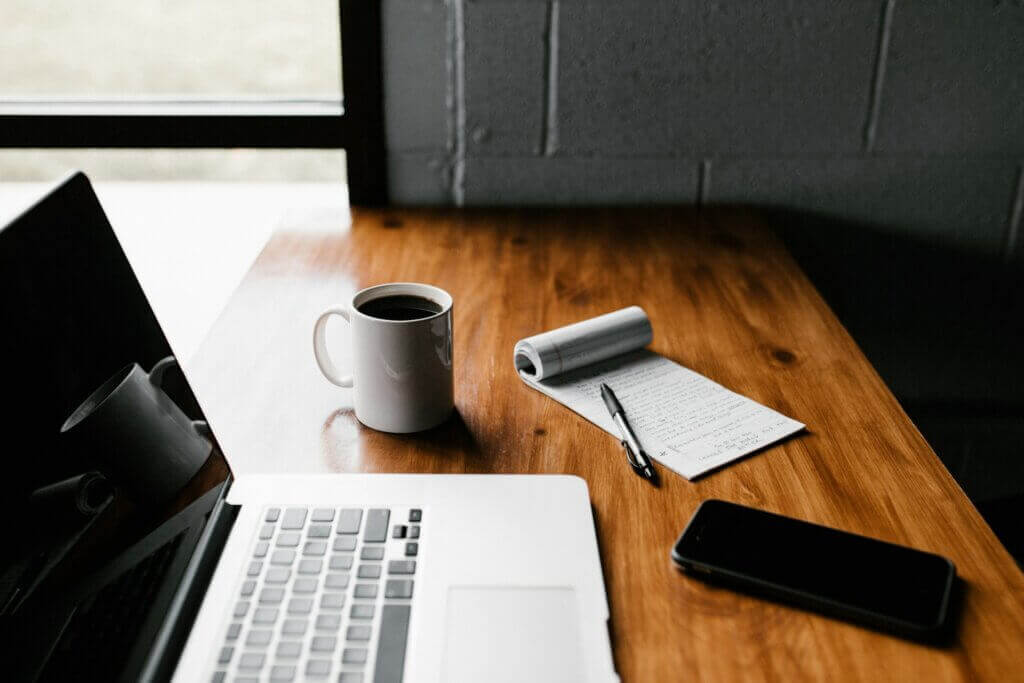 SEO Consultant Desk with a Laptop, Smartphone, Notepad, Pen, and Cup of Coffee